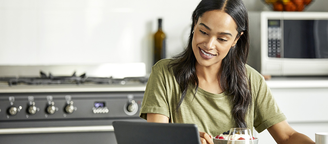 Young woman using laptop in kitchen