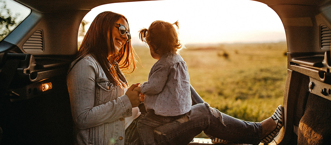 Mother and young daughter parked in recreational vehicle