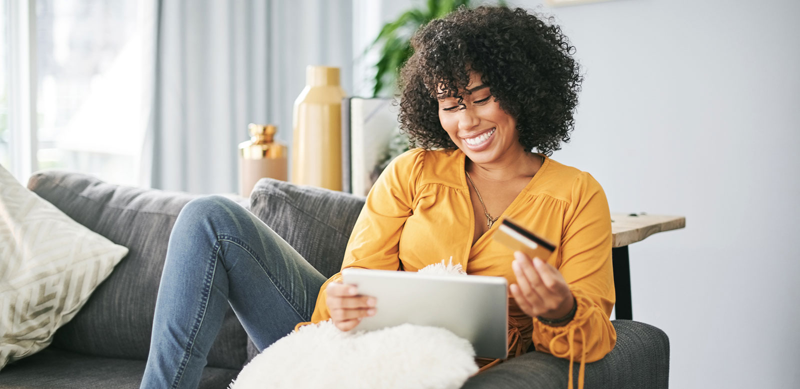 Young woman using laptop and debit card