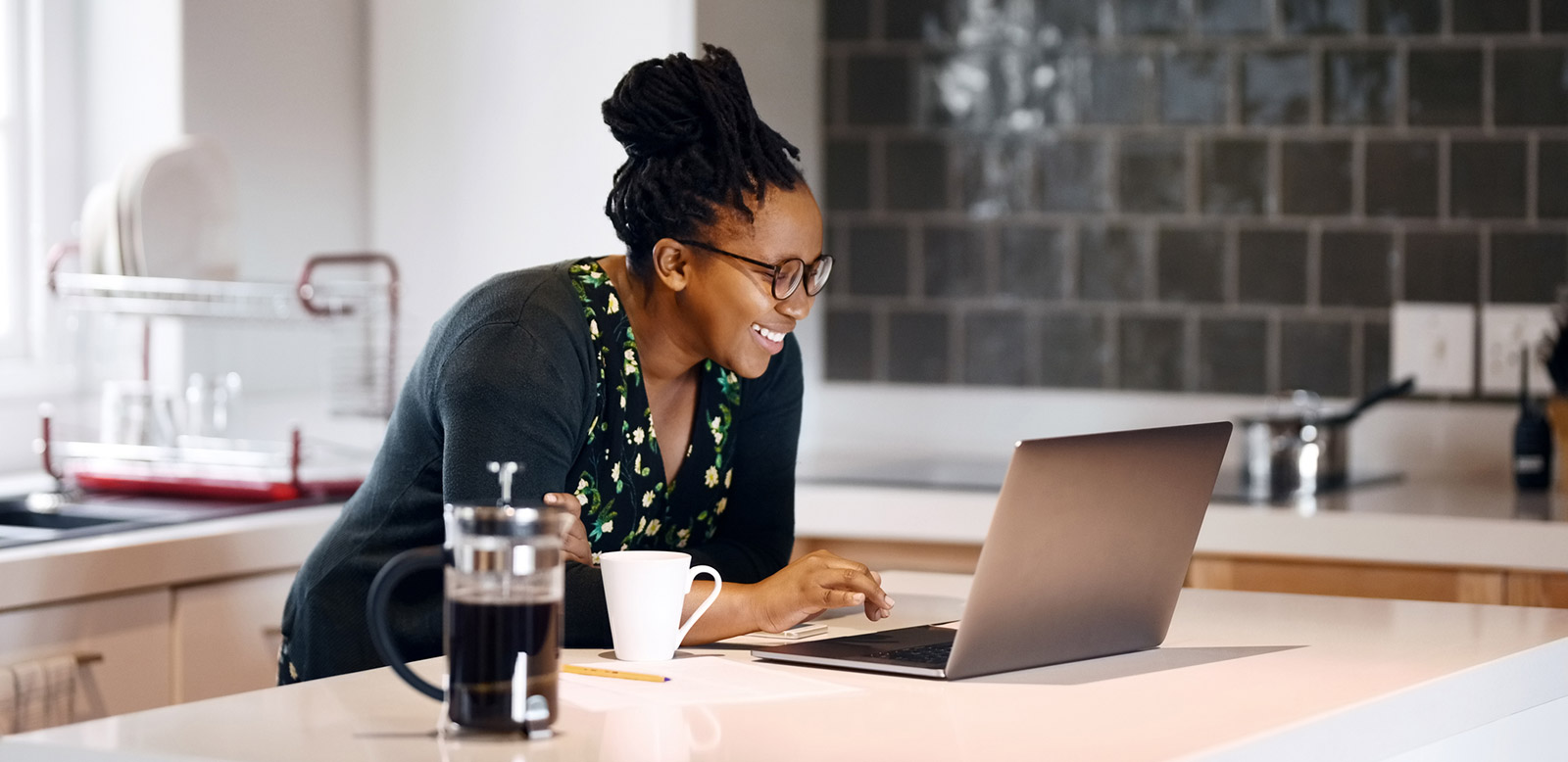 Woman working on laptop on kitchen